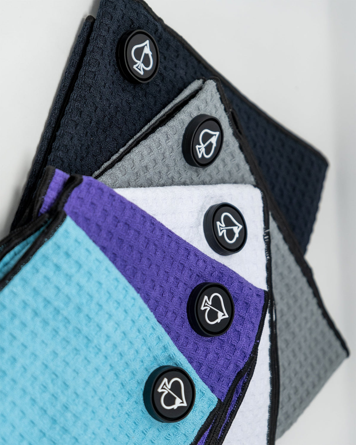 Magnetic black towel hanging from a sleek metal hook, showcasing its versatile design and functionality.