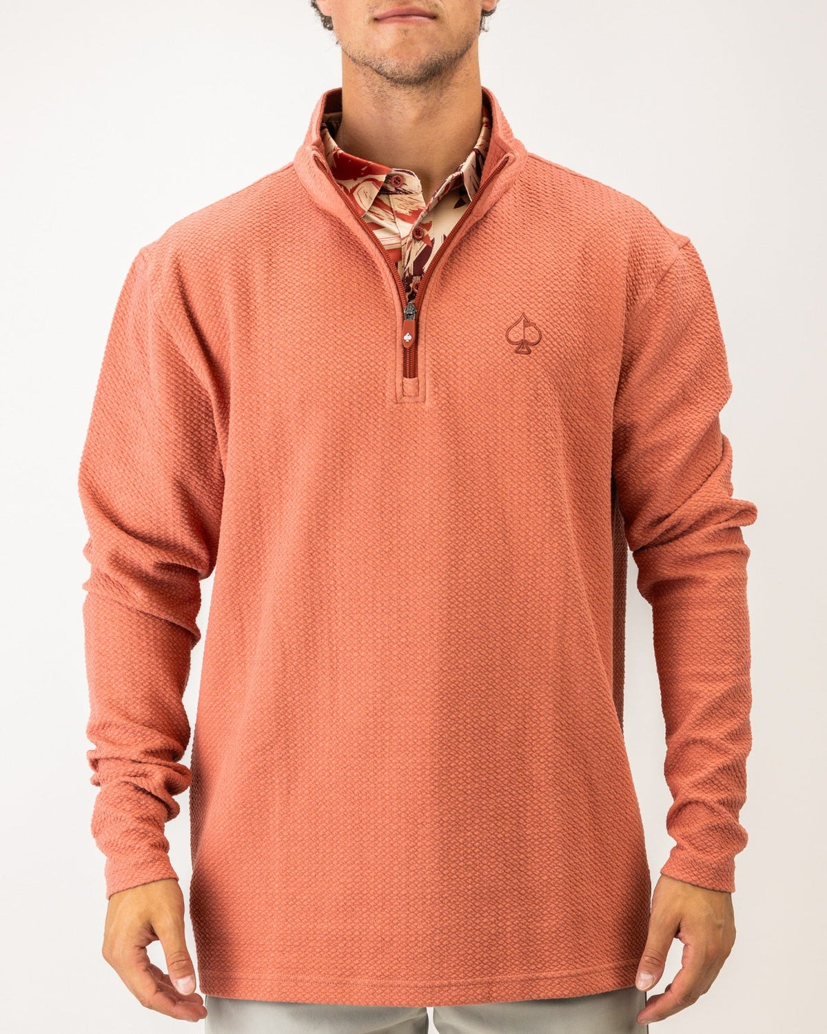 Terracotta waffle knit pullover with a quarter zip and logo, perfect for stylish comfort on the golf course.