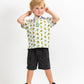 Youth wearing a TMNT Cowabunga Classic 8-Bit polo shirt featuring colorful turtle graphics, paired with black shorts.