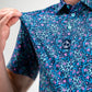 Fluorescent floral print dress on model, showcasing vibrant colors and modern design against a neutral background.