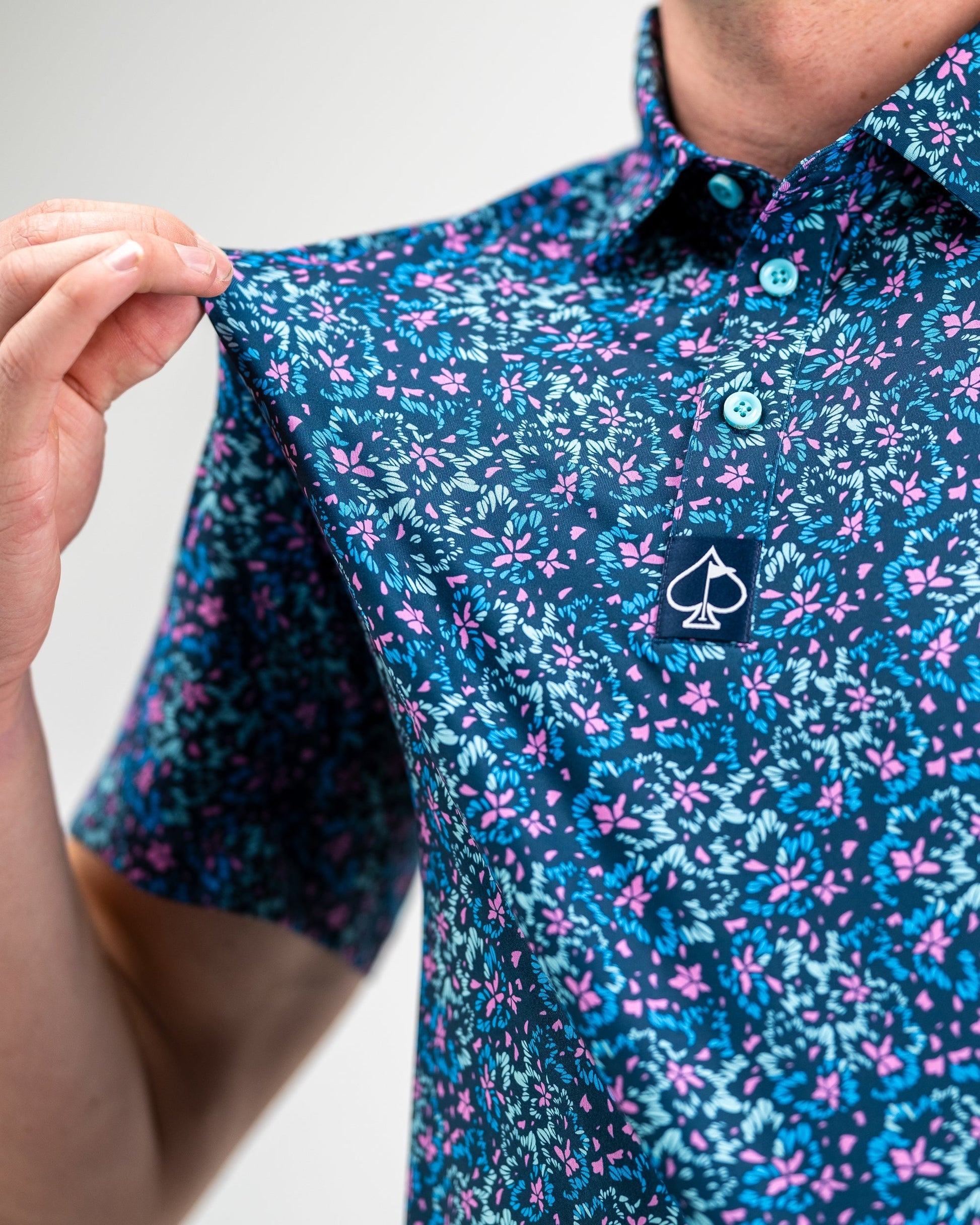 Fluorescent floral print dress on model, showcasing vibrant colors and modern design against a neutral background.