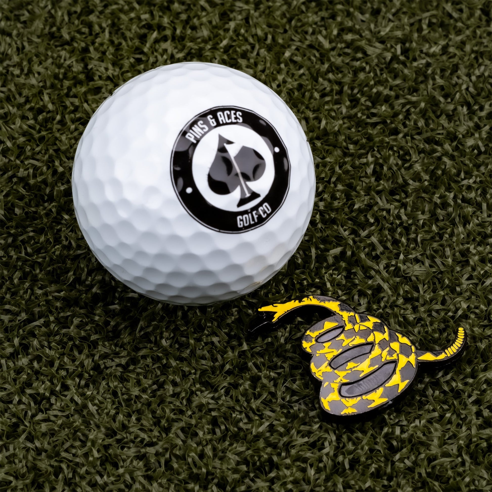 Don't Tread on Me ball marker featuring a coiled snake design, set against a golf ball background.