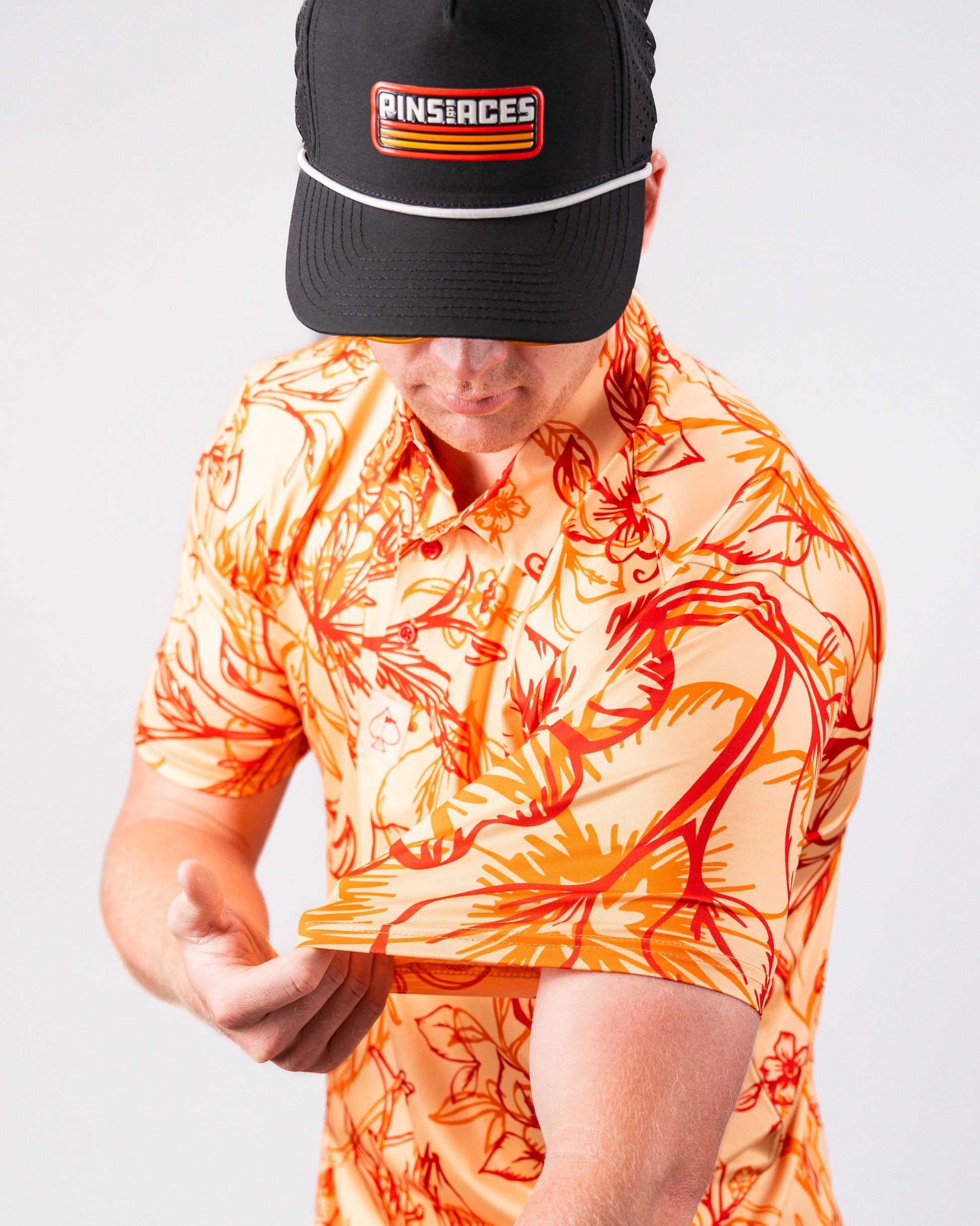 Cabo Sunburst polo shirt in vibrant orange, featuring a classic collar and short sleeves.