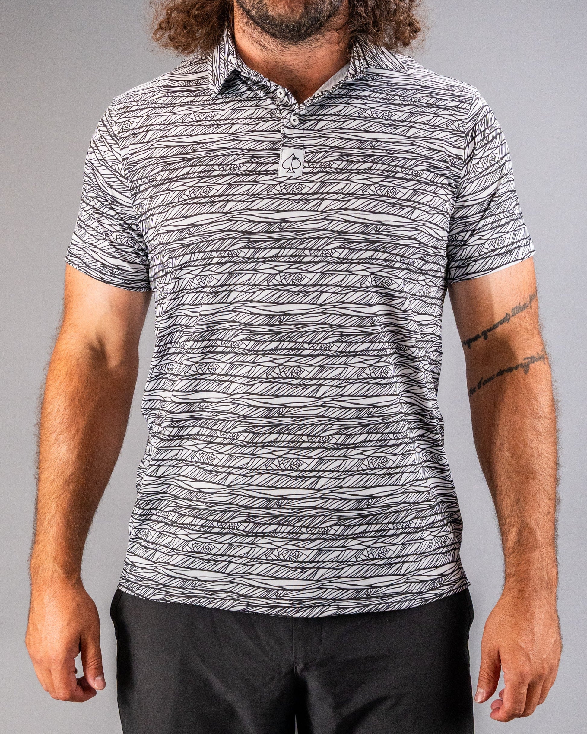 Men's Fragment Black golf polo featuring a bold abstract pattern, designed for style and performance on the course.
