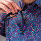 Bold floral golf shirt featuring vibrant lavender and multicolored flowers, with a stylish collar and unique button details.