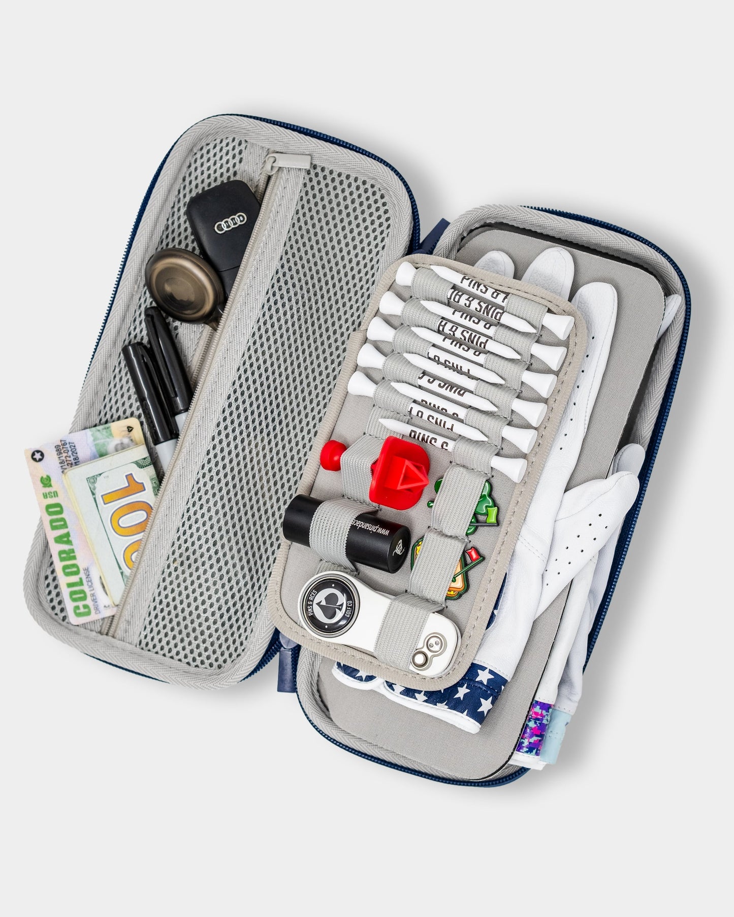 Gray glove and accessory caddie with multiple compartments, featuring an open design and decorative props.