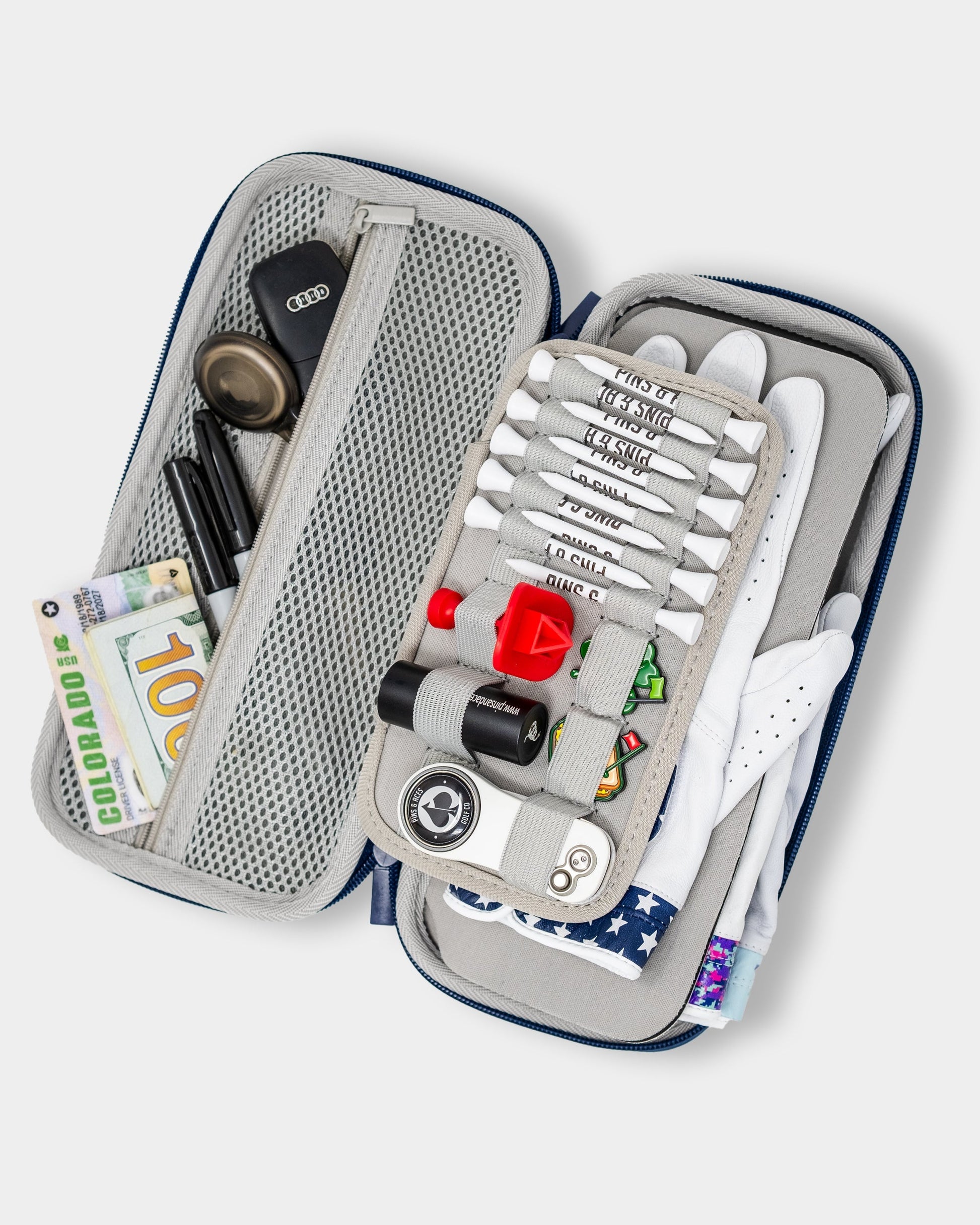 Gray glove and accessory caddie with multiple compartments, featuring an open design and decorative props.