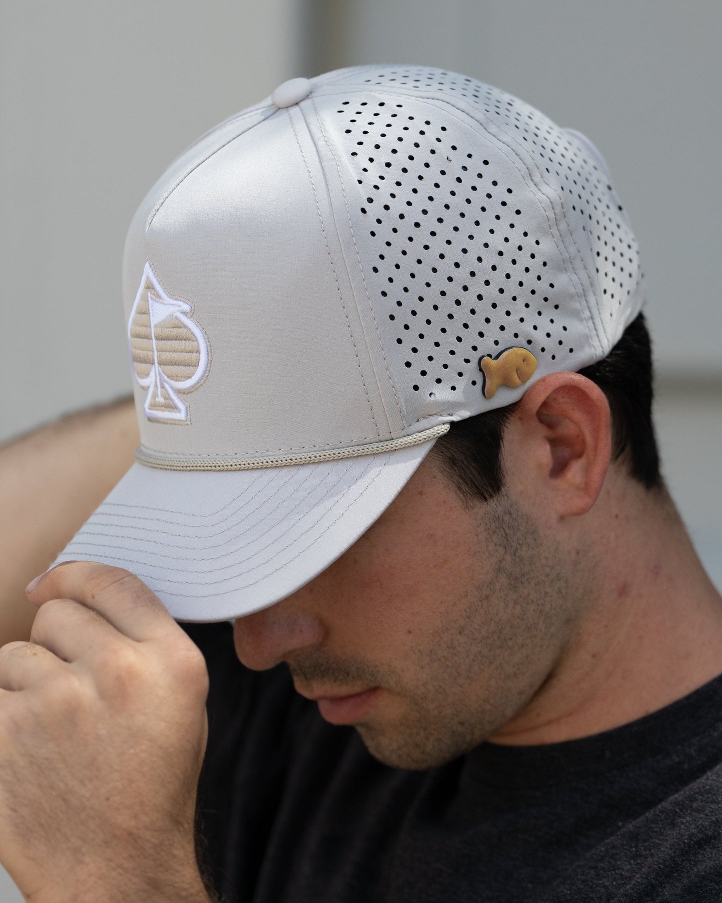 Perforated bone-colored rope hat with a stylish design, displayed in a lifestyle setting.