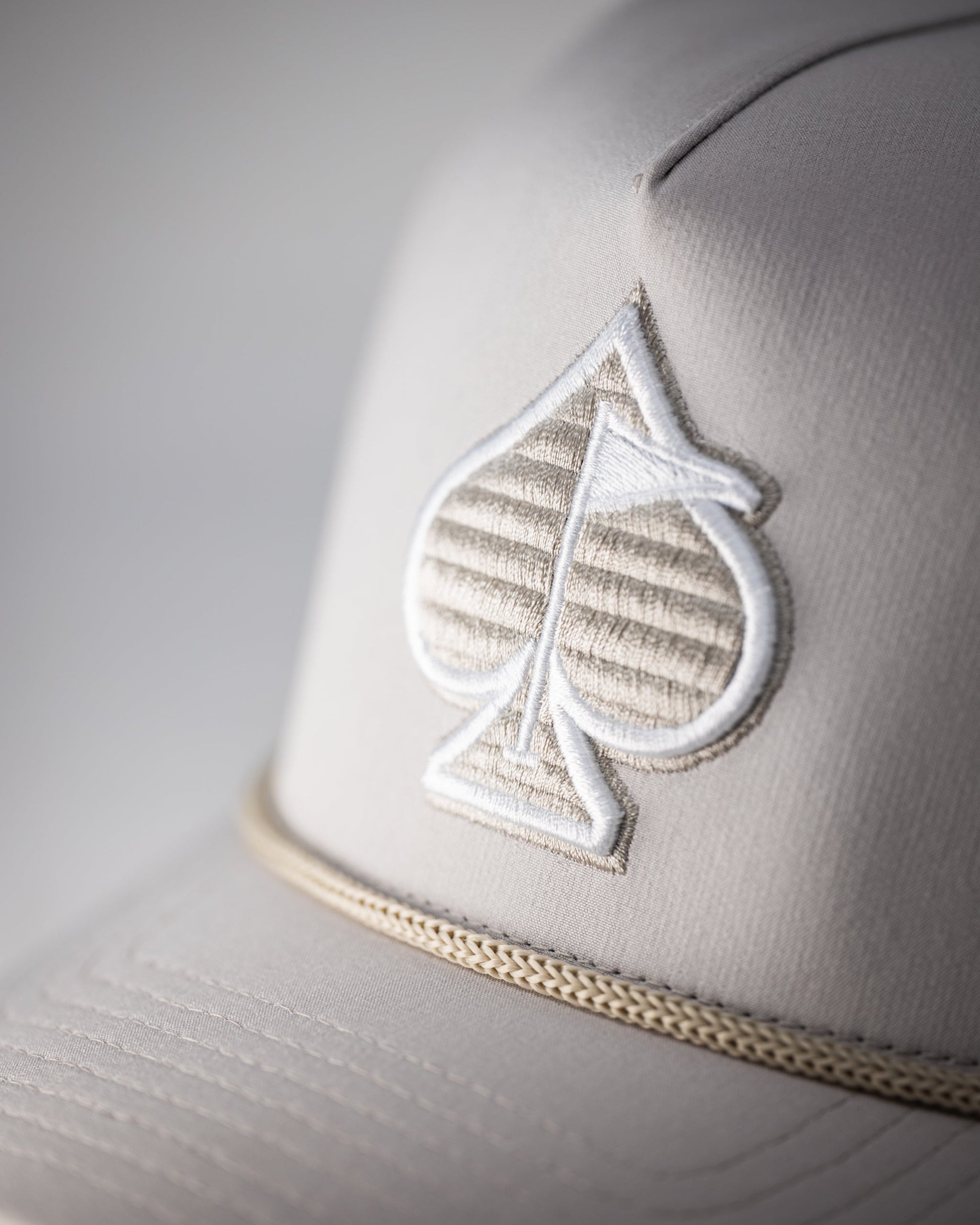 Perforated Bone Rope Hat with adjustable chin strap and classic design.
