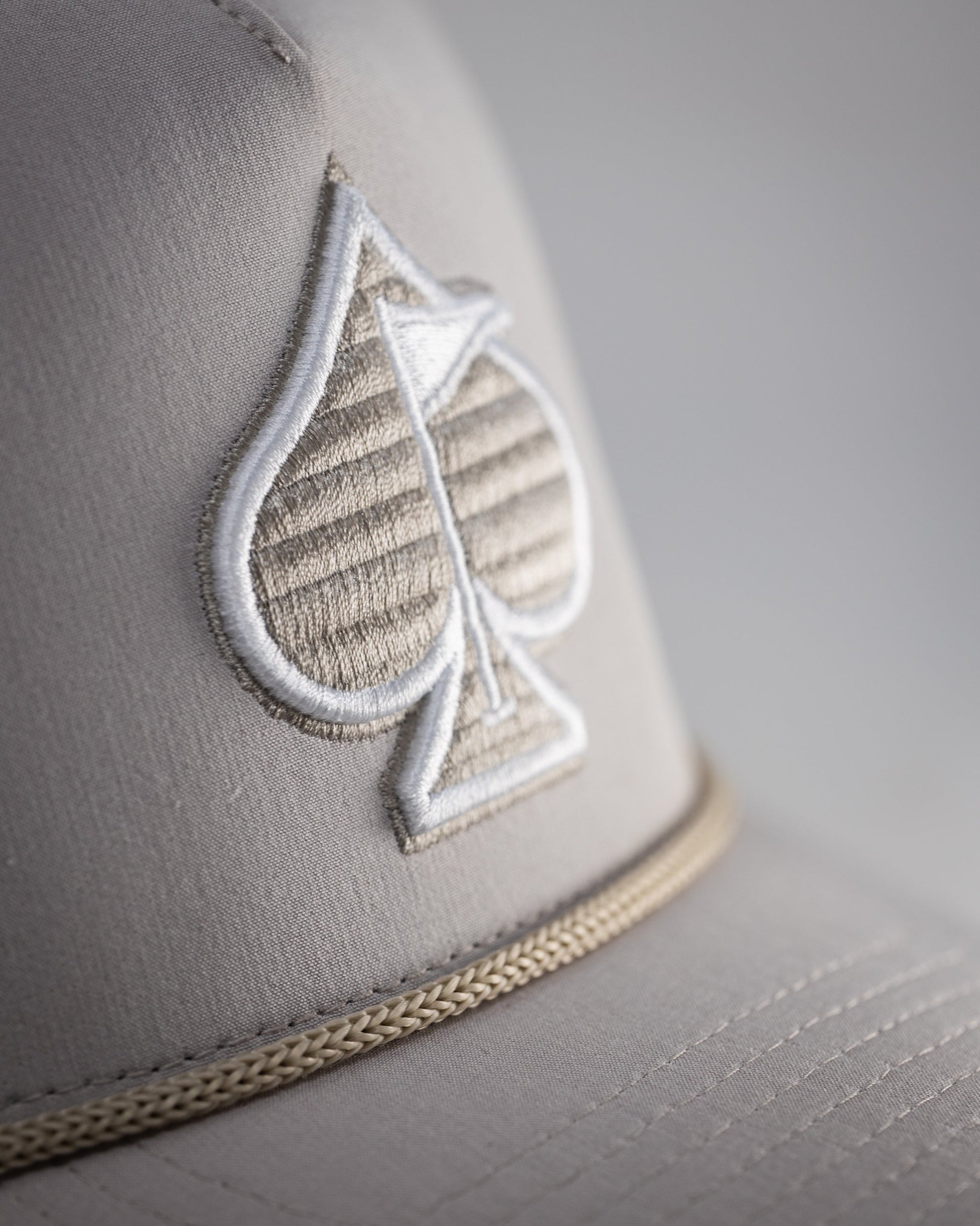 Perforated Bone Rope Hat with a stylish design and adjustable chin strap.