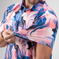 A golfer showcases the vibrant Melting Floral polo shirt, highlighting its colorful floral design and lightweight fabric.