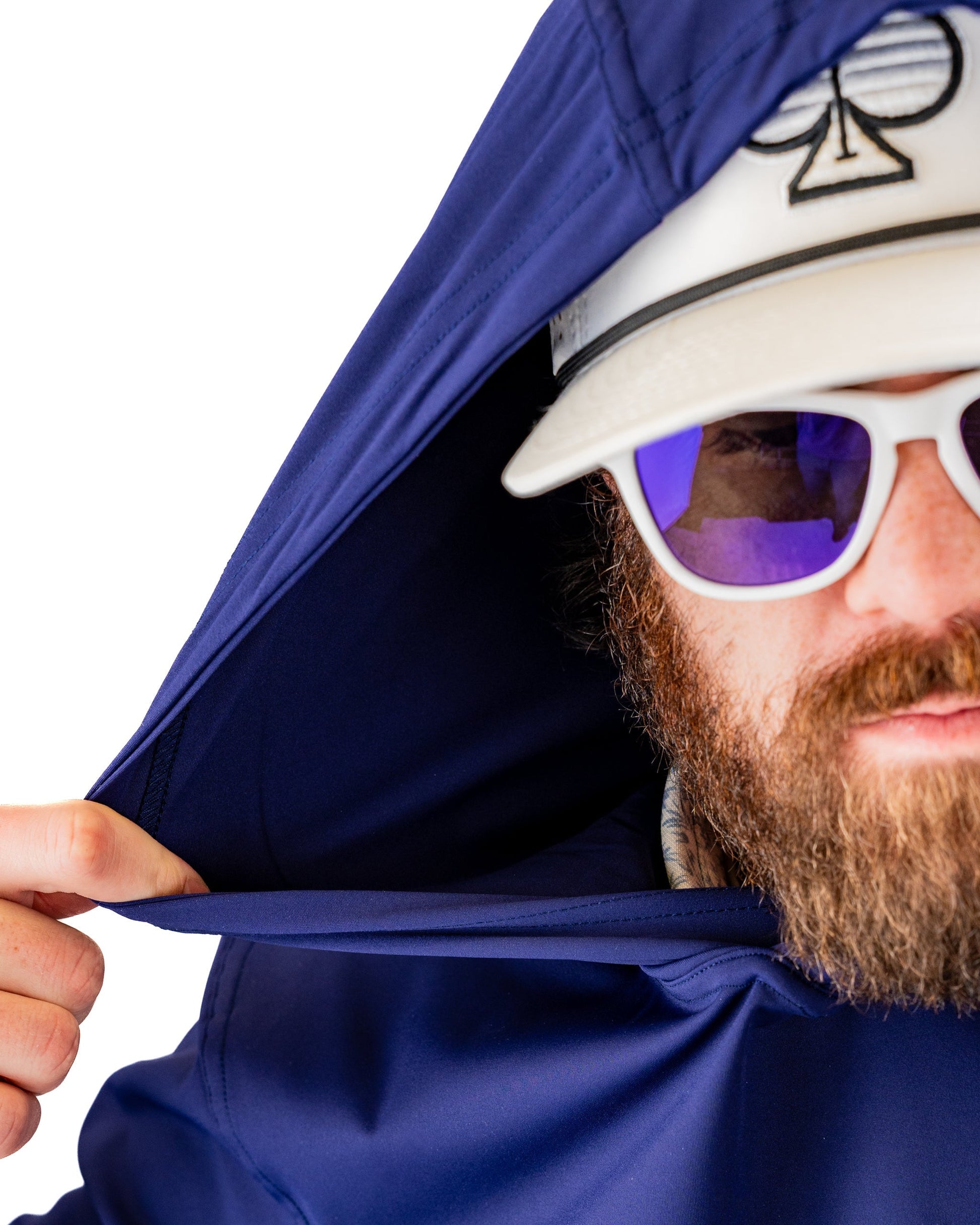 Navy performance golf hoodie with a man adjusting the hood, wearing sunglasses and a golf cap.