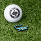 Nessie Ball Marker featuring a whimsical Loch Ness Monster design next to a golf ball on a green surface.