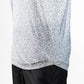 Close-up of a Player Preferred™ Polo in olive grove with a small blue floral pattern, paired with black pants.
