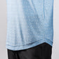 Close-up of a light blue Player Preferred™ Polo shirt with a subtle wave pattern, worn over black pants.