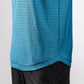 Close-up of a blue Player Preferred™ Polo shirt with a geometric pattern, worn over black pants.
