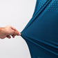 Close-up of a hand stretching a navy Player Preferred™ Polo shirt with Spade Fade pattern, showing the fabric's stretch and texture.