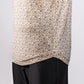 Close-up of a beige Player Preferred™ Polo with a small, dark geometric pattern, paired with black pants.