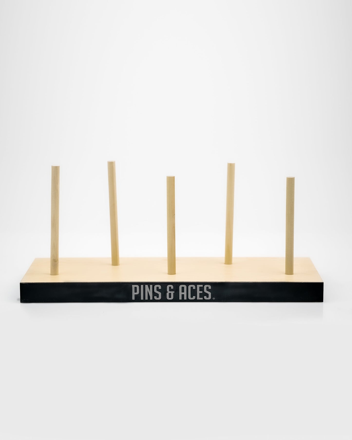Wooden golf club headcover display with "PINS & ACES" logo, perfect for bold golf apparel and unique accessories.