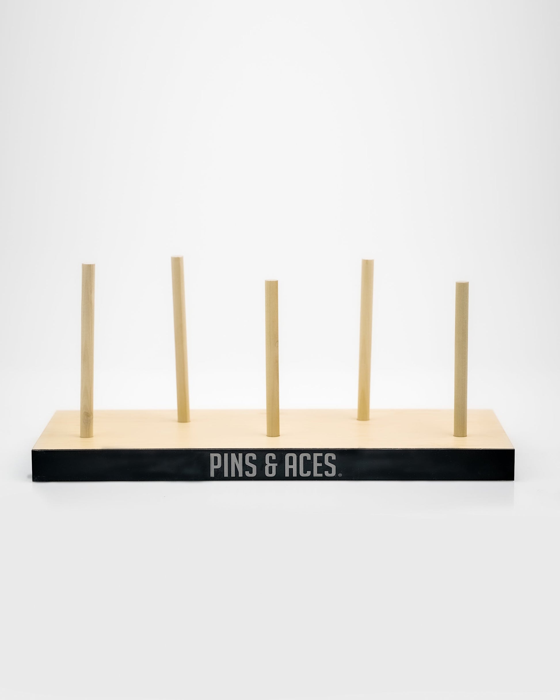 Wooden golf club headcover display with "PINS & ACES" logo, perfect for bold golf apparel and unique accessories.