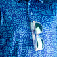 Bold blue golf shirt featuring a playful doodle pattern with TMNT graphics, paired with stylish sunglasses.