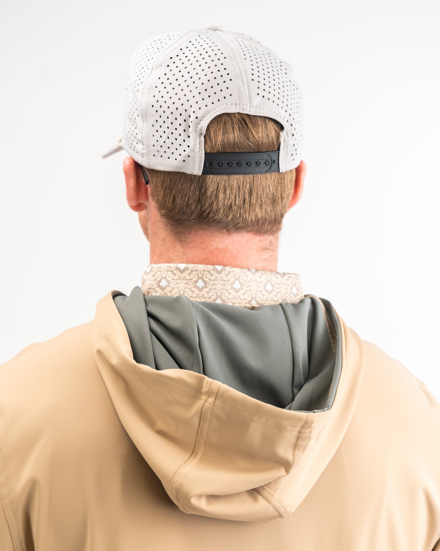 Men's performance golf hoodie in sand color, featuring a lightweight design and stylish layered look with a patterned collar.