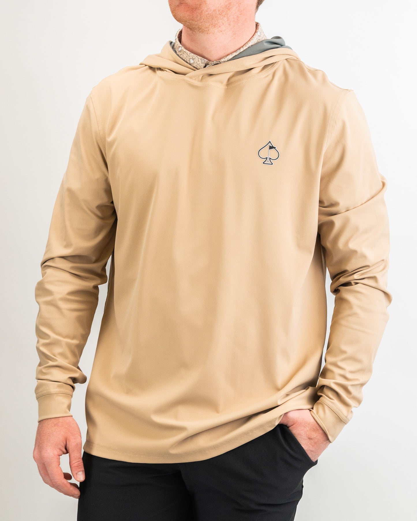 Men's performance golf hoodie in sand color, featuring a sleek design and spade logo, ideal for stylish comfort on the course.