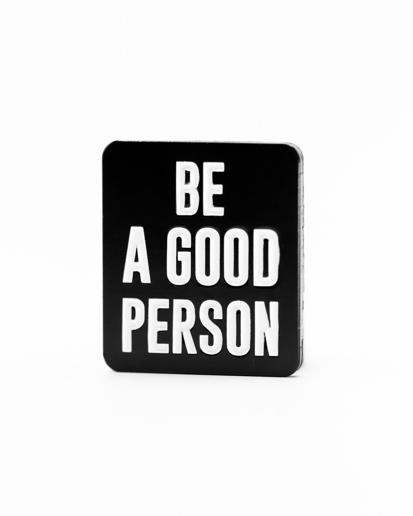 Black ball marker featuring the phrase "Be A Good Person" in bold white letters, perfect for golfers who value positivity.