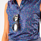 Women's sleeveless golf shirt featuring a vibrant lavender floral pattern, paired with stylish sunglasses.