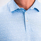 Player Preferred™ Polo in Tidal Flow color, featuring a sleek design and breathable fabric, displayed on a wooden table with a subtle background.