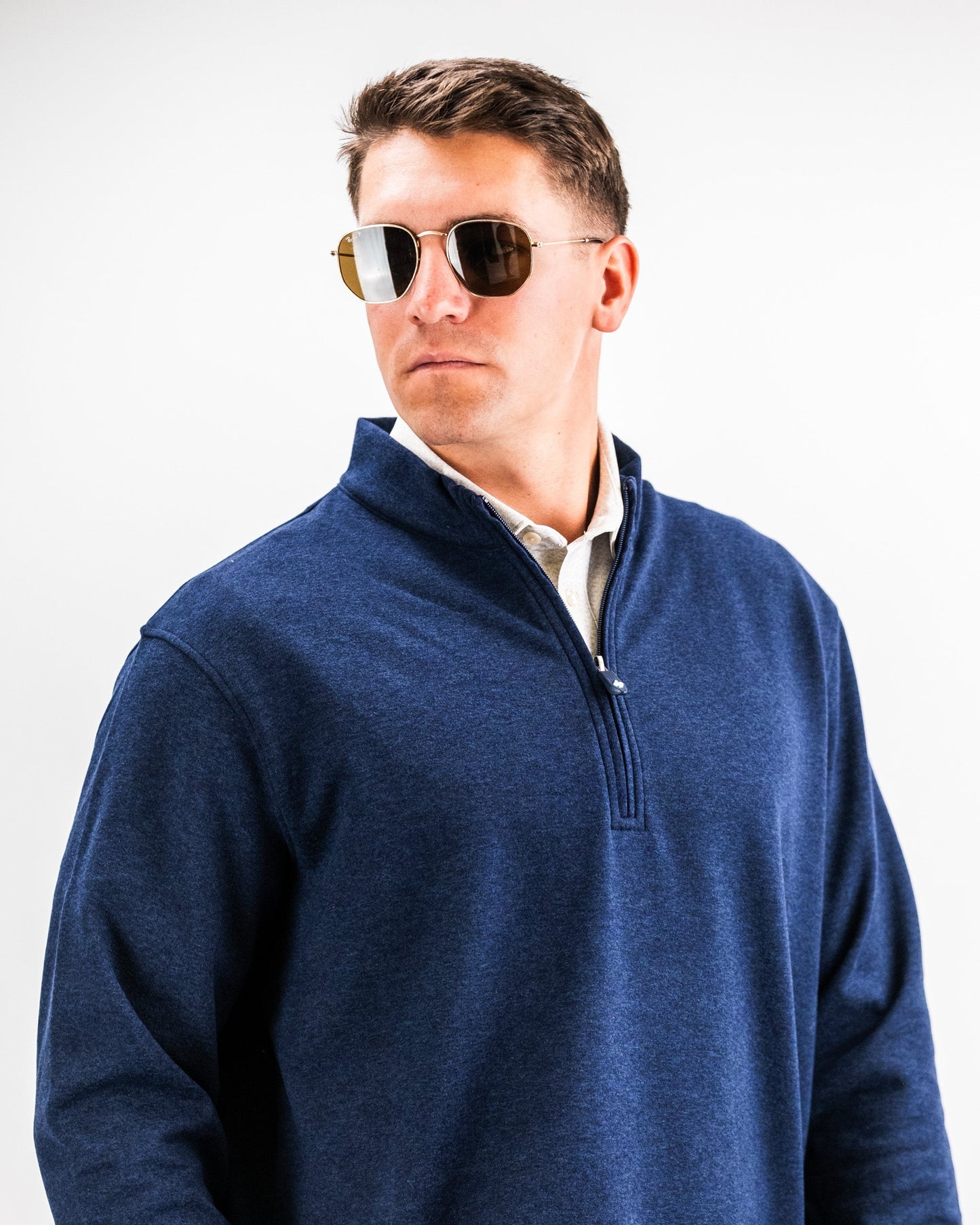 Man wearing a navy heathered Player Preferred™ Pullover with sunglasses, facing slightly to the side against a plain background.