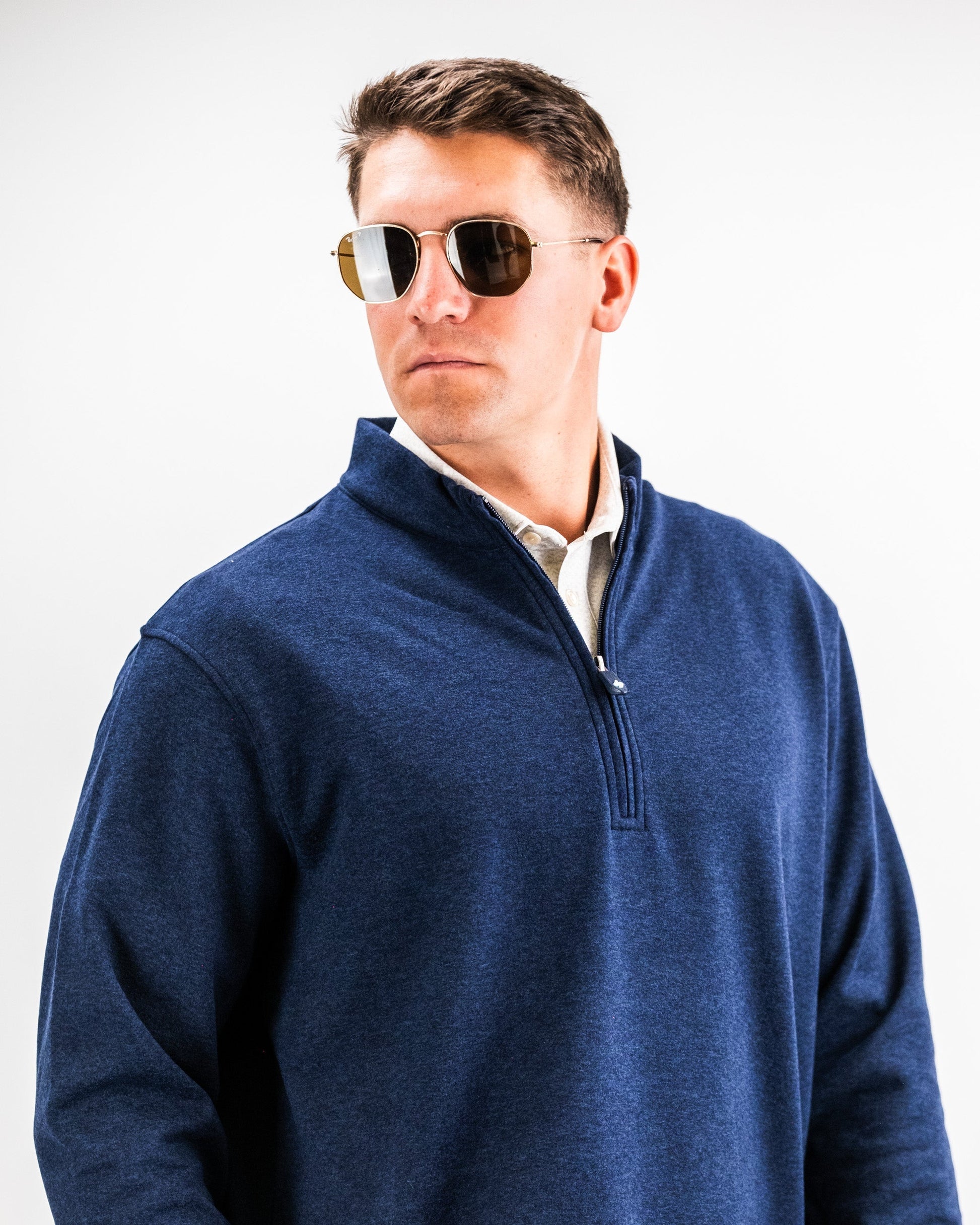 Man wearing a navy heathered Player Preferred™ Pullover with sunglasses, facing slightly to the side against a plain background.