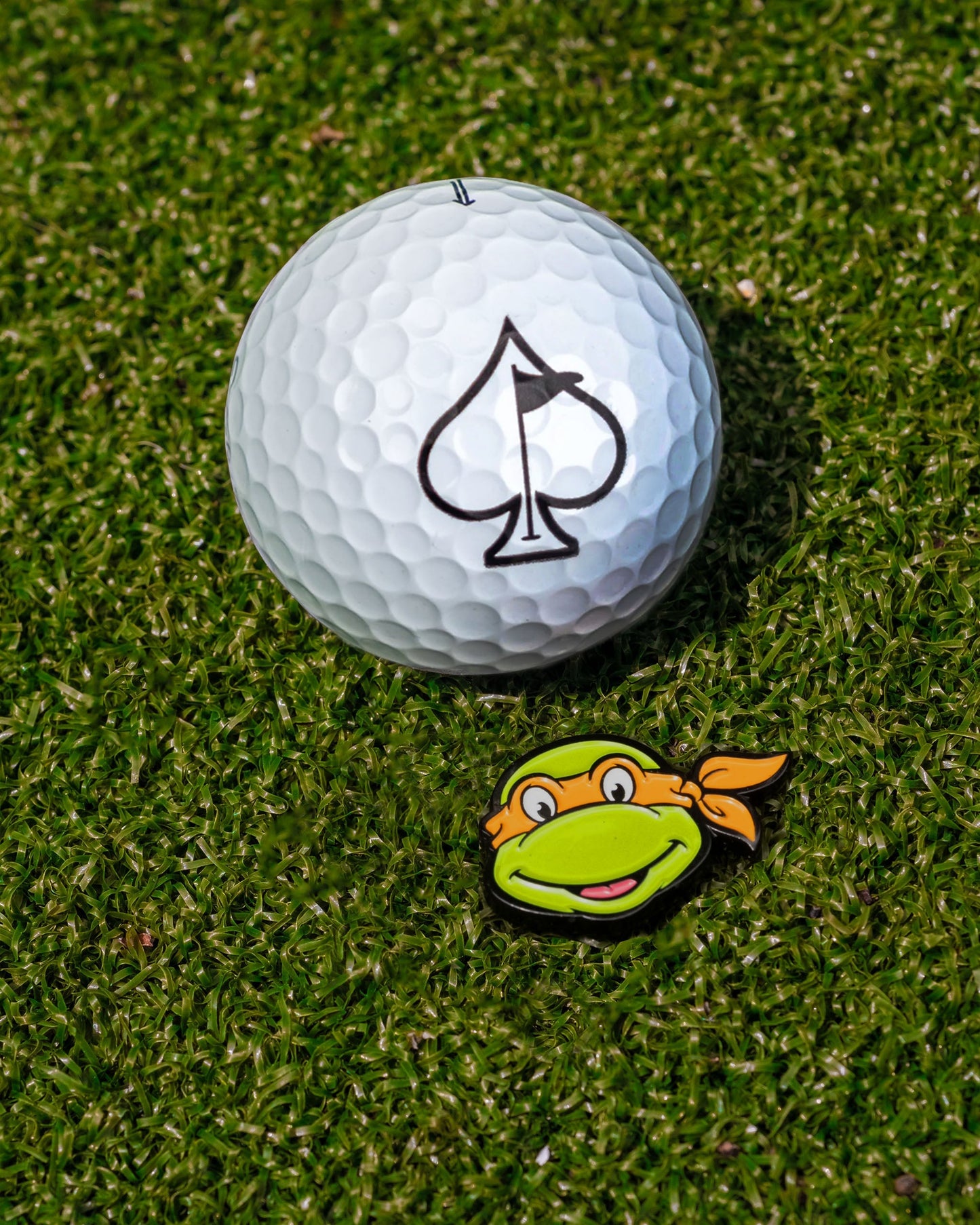 TMNT Michelangelo ball marker featuring a vibrant design of the character's face in green and orange.