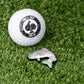 Trout ball marker featuring a detailed trout design, positioned beside a golf ball on a grassy surface.