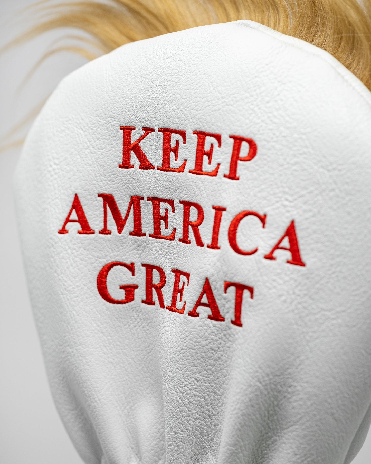 "Trump-themed driver golf club cover featuring a caricature of Donald Trump's head and signature hairstyle."