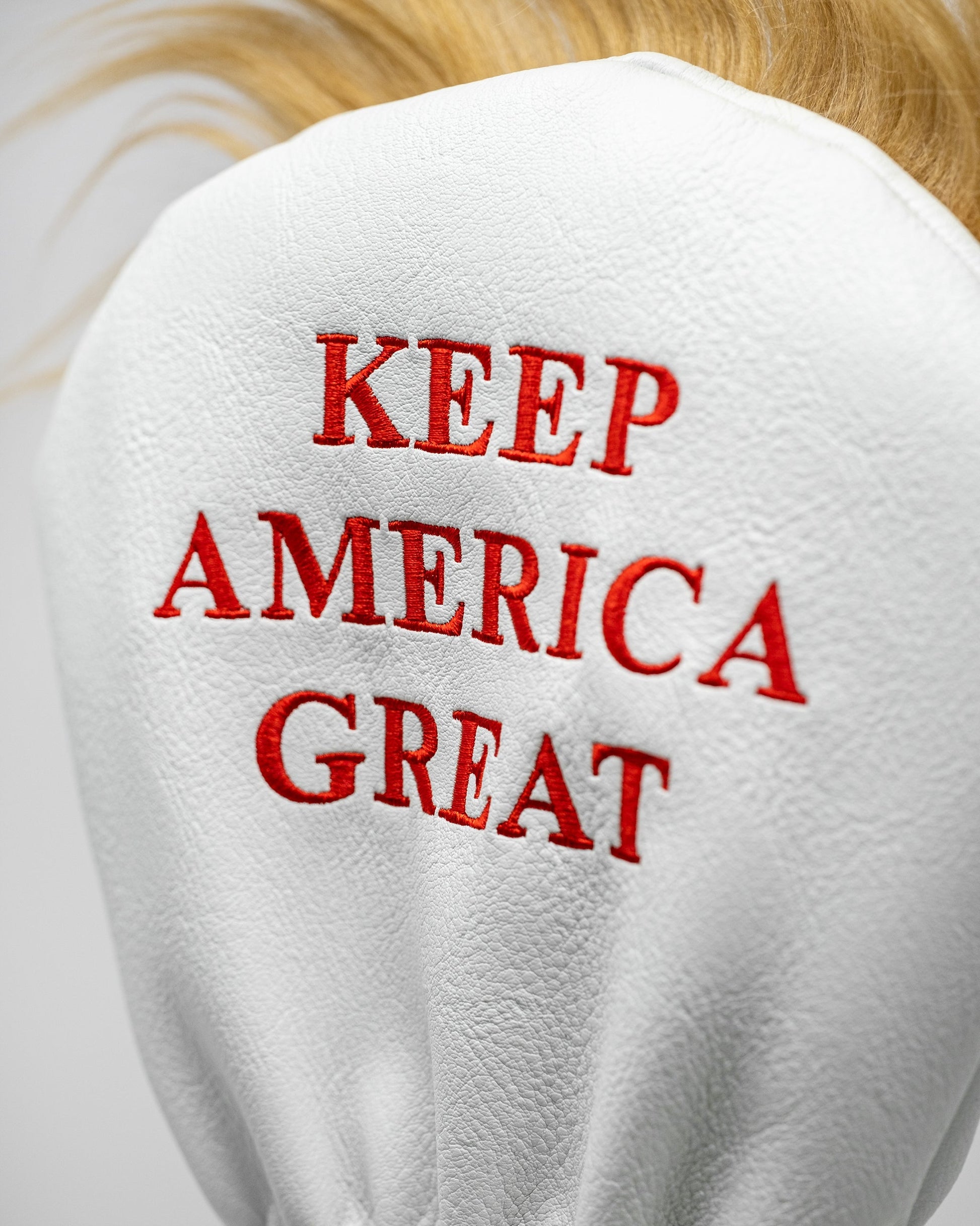 "Trump-themed driver golf club cover featuring a caricature of Donald Trump's head and signature hairstyle."