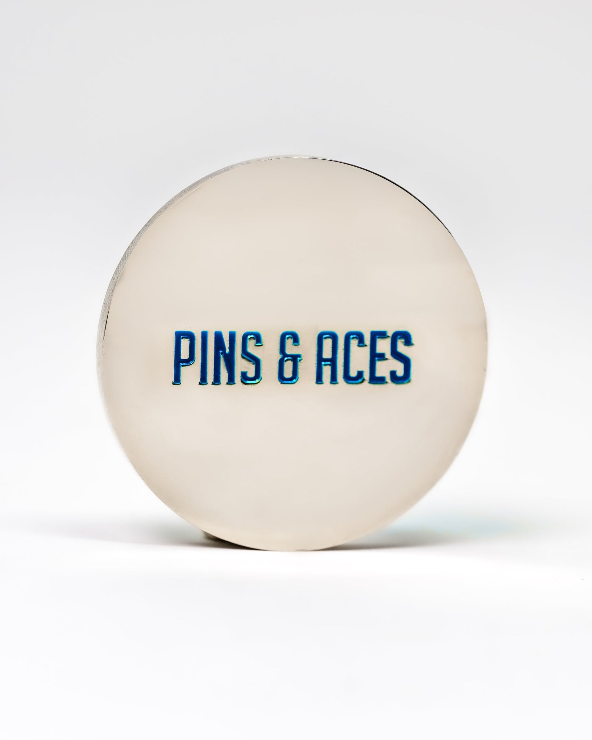 Cool Mint ball marker featuring "PINS & ACES" in bold blue lettering on a sleek silver surface.