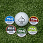 Alt text: "A golf ball with a spade symbol on a dense artificial grass surface, surrounded by five colorful disc-shaped ball markers labeled P&A in flavors Cool Mint, Cinnamon, Smooth, Spearmint, and Citrus."