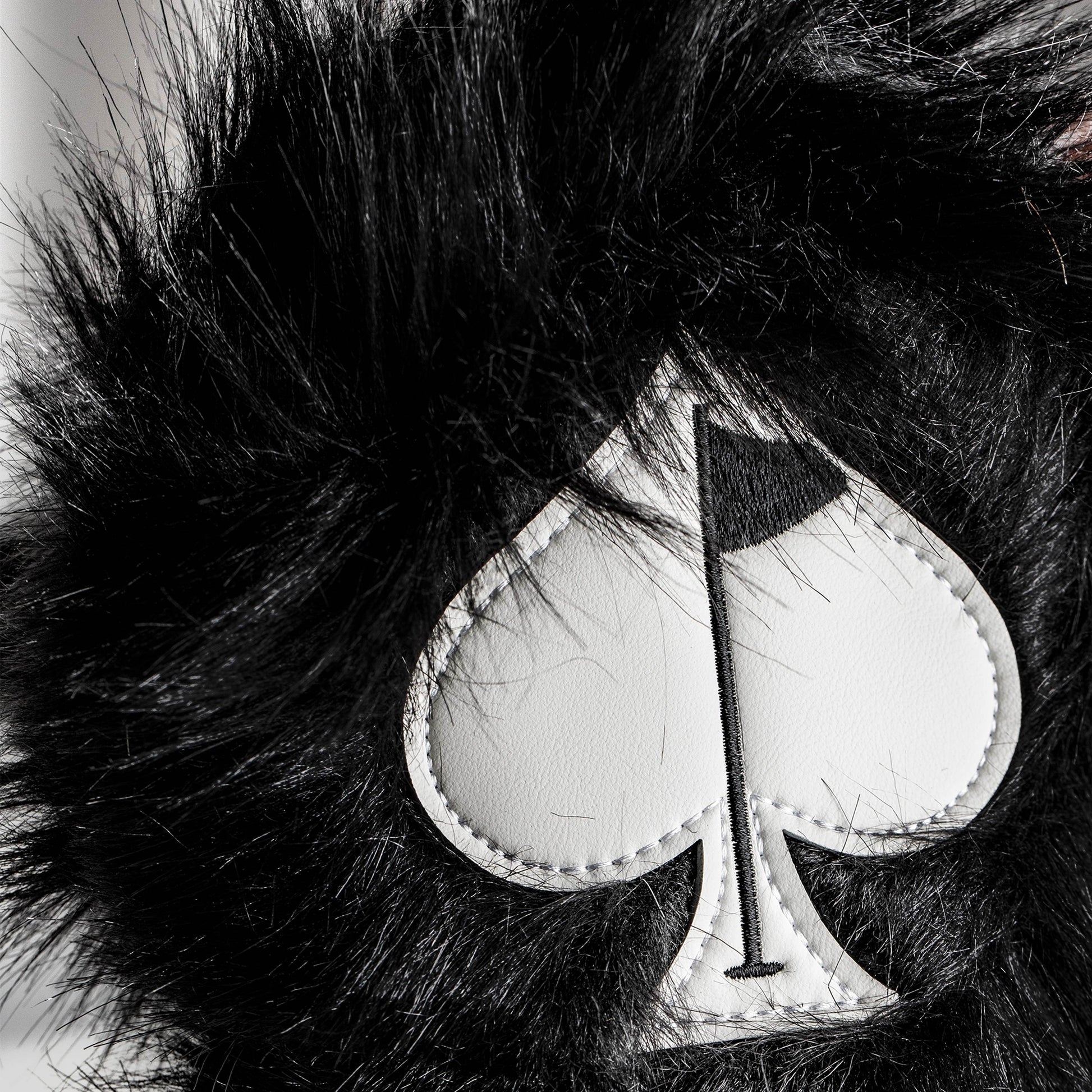 Black fuzzy driver cover for golf club, featuring a sleek design and soft texture.